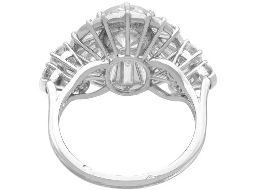 fig 6. An Art Deco platinum ballerina ring featuring a prominent round central diamond surrounded by a radiating halo of tapered baguette cut diamonds.