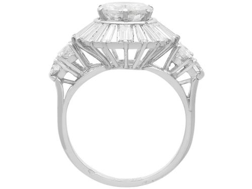 fig 7. An Art Deco platinum ballerina ring featuring a prominent round central diamond surrounded by a radiating halo of tapered baguette cut diamonds.