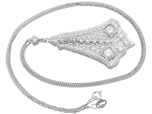 fig 6. An Art Deco 14ct white gold pendant featuring geometric pierced filigree lattice work set with multiple diamonds suspended from a chain.