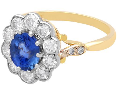 fig 4. An 18ct yellow gold cluster ring featuring an oval blue sapphire surrounded by a halo of round diamonds set in platinum.