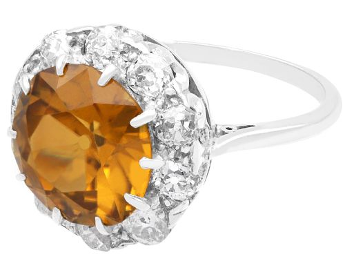 fig 7. An antique Art Deco platinum ring featuring a central round orange zircon surrounded by a halo of claw-set diamonds.