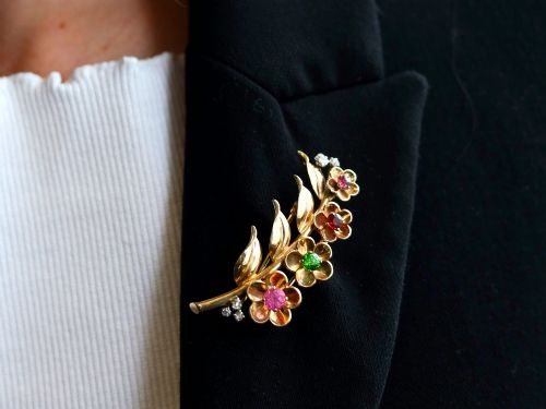 fig 3. An antique 9ct yellow gold floral spray brooch featuring four carved flower heads set with colourful gemstones and diamond accents.