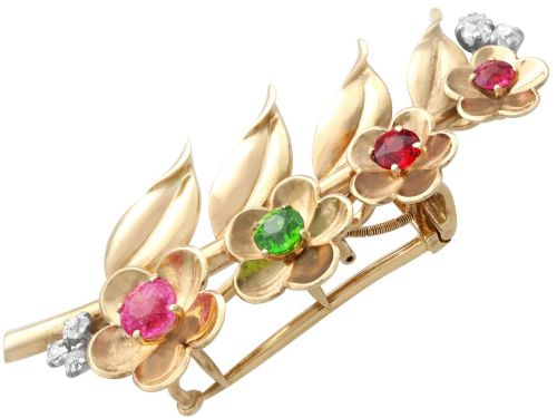fig 6. An antique 9ct yellow gold floral spray brooch featuring four carved flower heads set with colourful gemstones and diamond accents.