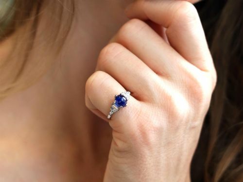 fig 2. An Art Deco platinum dress ring set with a central oval cabochon blue sapphire flanked by stepped geometric shoulders of baguette cut diamonds.