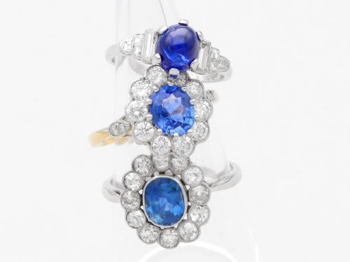 fig 4. An Art Deco platinum dress ring set with a central oval cabochon blue sapphire flanked by stepped geometric shoulders of baguette cut diamonds.