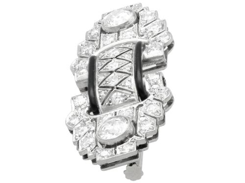 fig 6. An Art Deco platinum brooch featuring geometric stepped motifs, diamond pave setting, central lattice detail, and black enamel accents.