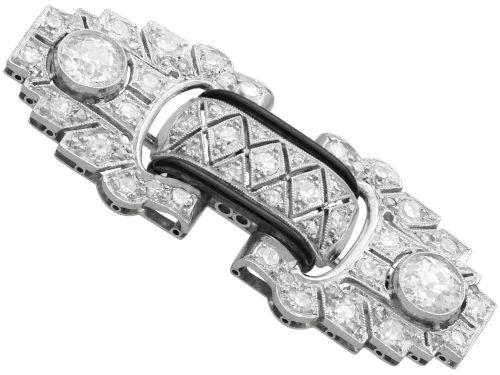 fig 7. An Art Deco platinum brooch featuring geometric stepped motifs, diamond pave setting, central lattice detail, and black enamel accents.