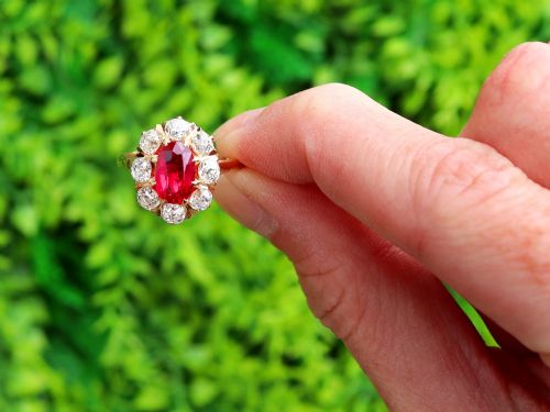 fig 1. An 18ct rose gold cluster ring featuring a central oval red ruby surrounded by eight old cut diamonds set in individual claw settings.