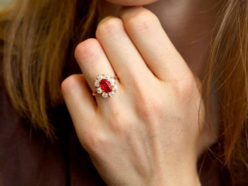 fig 4. An 18ct rose gold cluster ring featuring a central oval red ruby surrounded by eight old cut diamonds set in individual claw settings.