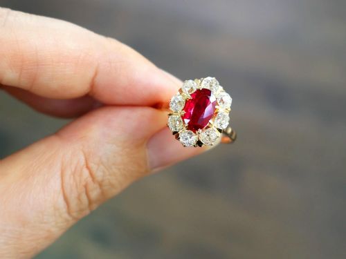 fig 5. An 18ct rose gold cluster ring featuring a central oval red ruby surrounded by eight old cut diamonds set in individual claw settings.
