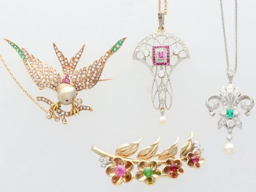 fig 4. An antique Victorian 18ct yellow gold bird brooch set with diamonds on the wings, emeralds along the outer feathers, a natural pearl body, and ruby details.