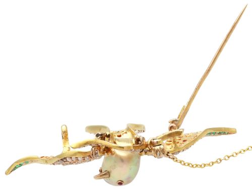 fig 8. An antique Victorian 18ct yellow gold bird brooch set with diamonds on the wings, emeralds along the outer feathers, a natural pearl body, and ruby details.
