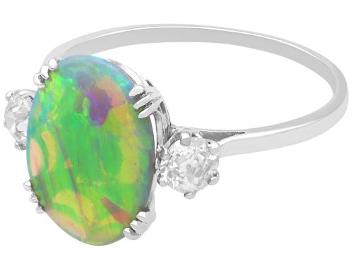 fig 7. An antique platinum trilogy ring featuring a central oval cabochon opal flanked by two round cut diamonds.