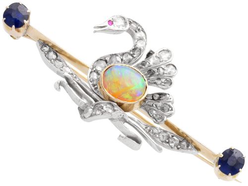 fig 5. An antique Victorian 9ct gold bar brooch featuring a central swan motif set with diamonds and an oval opal body, flanked by two blue sapphires.