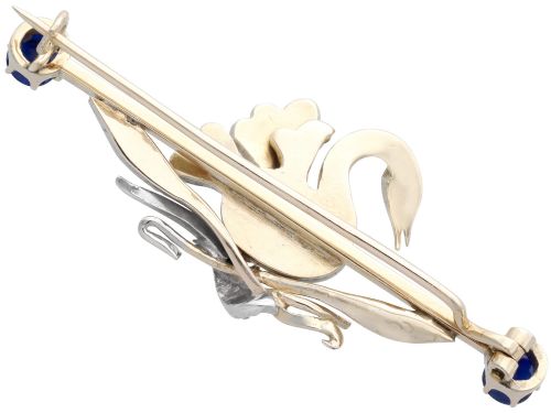 fig 6. An antique Victorian 9ct gold bar brooch featuring a central swan motif set with diamonds and an oval opal body, flanked by two blue sapphires.