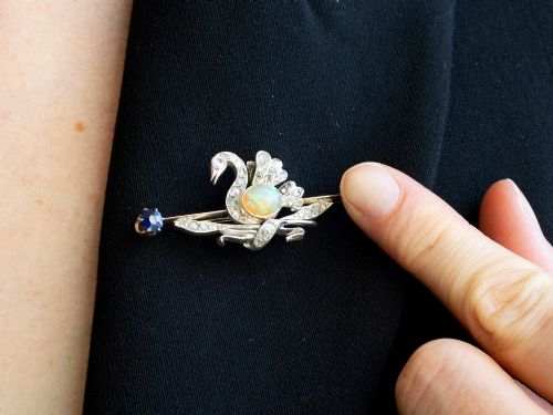 fig 10. An antique Victorian 9ct gold bar brooch featuring a central swan motif set with diamonds and an oval opal body, flanked by two blue sapphires.
