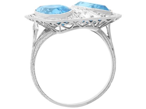 fig 7. An Art Deco platinum cocktail ring featuring two pear-cut light blue aquamarines set diagonally beside a central row of round diamonds with millegrain borders.