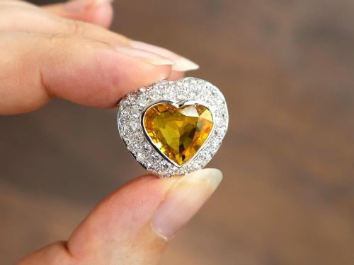 fig 4. A platinum heart-shaped pendant set with a central faceted yellow sapphire surrounded by a double border of round diamonds.