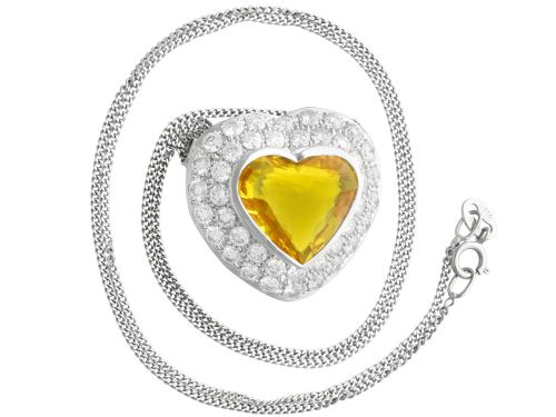 fig 8. A platinum heart-shaped pendant set with a central faceted yellow sapphire surrounded by a double border of round diamonds.