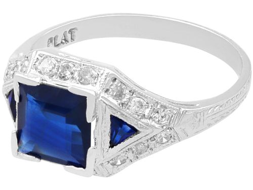 fig 4. An Art Deco platinum ring featuring a central rectangular step-cut blue sapphire flanked by triangular sapphires and diamond-set shoulder details.
