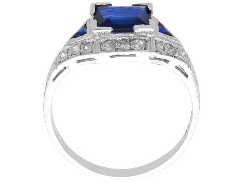 fig 6. An Art Deco platinum ring featuring a central rectangular step-cut blue sapphire flanked by triangular sapphires and diamond-set shoulder details.