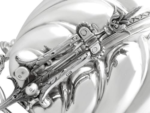 fig 9. An antique Victorian sterling silver folding biscuit box featuring shell-form compartments, an ornate looped handle, and an engraved 1897 monogram.
