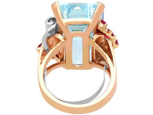 fig 6. A 1940s Retro rose gold cocktail ring set with a large emerald-cut aquamarine flanked by ruby clusters and diamond accents.