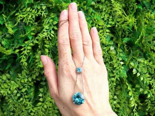 fig 1. An Art Deco 18ct white gold drop pendant set with two round brilliant-cut bright blue zircon gemstones suspended on delicate bar links.