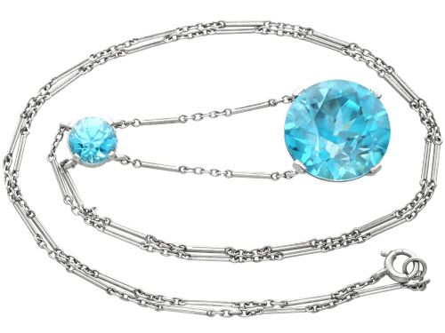 fig 6. An Art Deco 18ct white gold drop pendant set with two round brilliant-cut bright blue zircon gemstones suspended on delicate bar links.