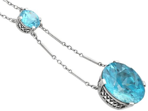 fig 7. An Art Deco 18ct white gold drop pendant set with two round brilliant-cut bright blue zircon gemstones suspended on delicate bar links.