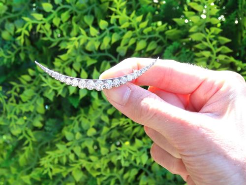 fig 1. An antique crescent-shaped brooch set with a row of graduated diamonds mounted in gold and silver.