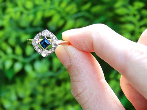 fig 1. An 18ct yellow gold ring featuring a central square blue sapphire surrounded by an openwork diamond-set frame.