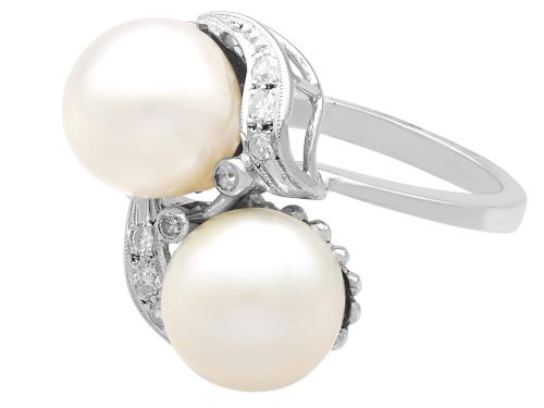 fig 6. A circa 1950 white gold crossover cocktail ring featuring two cultured pearls flanked by diamond-accented bypass shoulders.