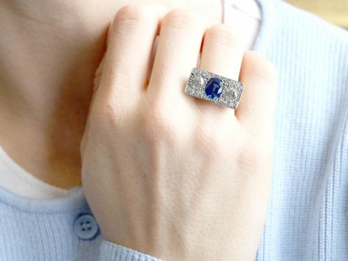 fig 3. An Art Deco platinum plaque ring set with a central blue sapphire flanked by two large diamonds and surrounded by smaller pave-set diamonds.