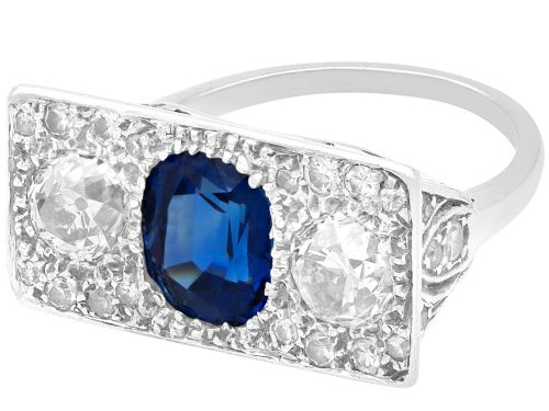 fig 6. An Art Deco platinum plaque ring set with a central blue sapphire flanked by two large diamonds and surrounded by smaller pave-set diamonds.