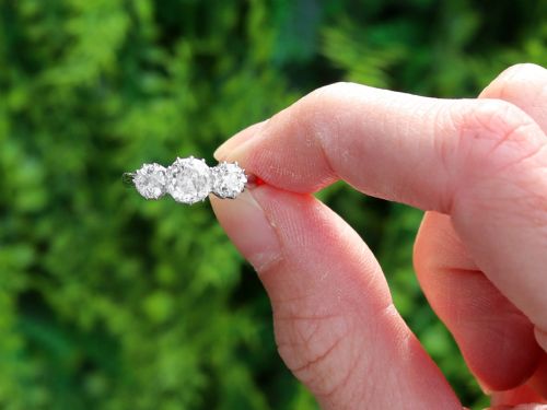fig 1. An Art Deco platinum ring set with three claw-set round diamonds positioned horizontally along the band.