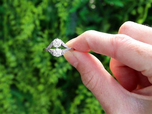 fig 1. An Art Deco platinum two stone ring featuring round diamonds arranged vertically within a crossover frame with diamond-set shoulders.