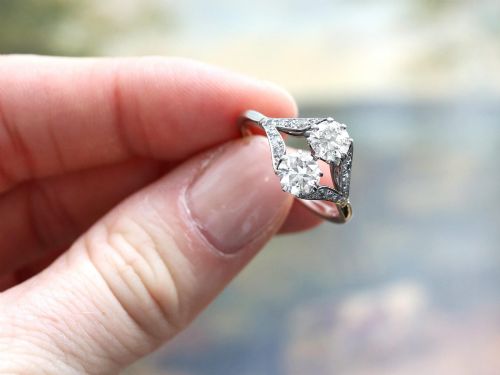 fig 2. An Art Deco platinum two stone ring featuring round diamonds arranged vertically within a crossover frame with diamond-set shoulders.