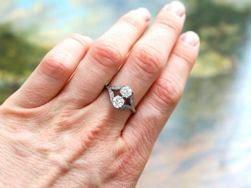 fig 3. An Art Deco platinum two stone ring featuring round diamonds arranged vertically within a crossover frame with diamond-set shoulders.