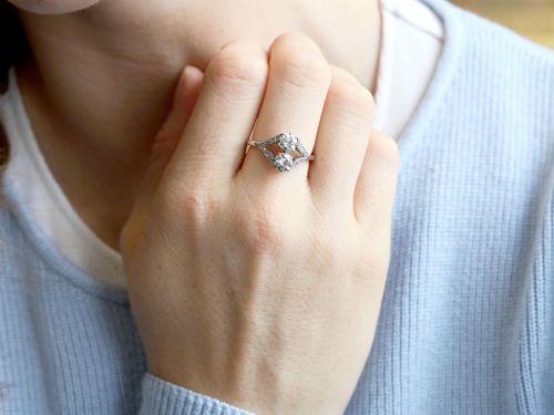 fig 4. An Art Deco platinum two stone ring featuring round diamonds arranged vertically within a crossover frame with diamond-set shoulders.