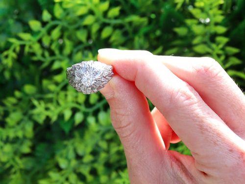 fig 1. An Art Deco 18ct white gold dress ring with engraved floral textured petals and a central diamond accent.