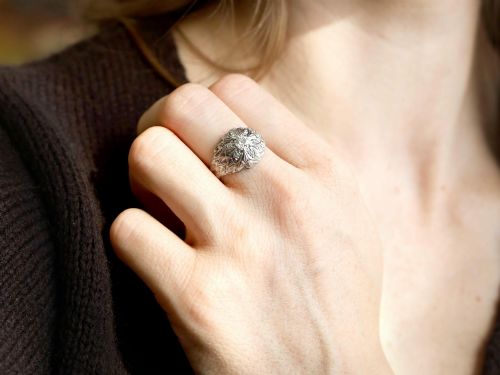 fig 3. An Art Deco 18ct white gold dress ring with engraved floral textured petals and a central diamond accent.