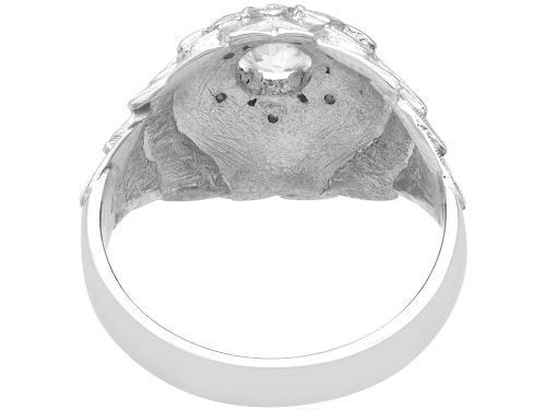 fig 5. An Art Deco 18ct white gold dress ring with engraved floral textured petals and a central diamond accent.