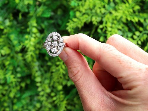 fig 1. A vintage 1950s 14ct white gold dress ring featuring a multi-diamond cluster and curved accent bands.