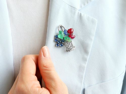 fig 3. An 18ct white gold Tutti Frutti basket brooch featuring carved emeralds, rubies, sapphire cabochons, and small diamonds.