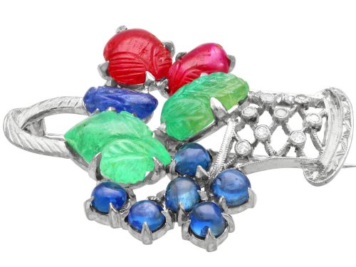 fig 6. An 18ct white gold Tutti Frutti basket brooch featuring carved emeralds, rubies, sapphire cabochons, and small diamonds.