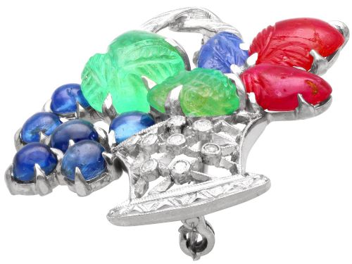 fig 7. An 18ct white gold Tutti Frutti basket brooch featuring carved emeralds, rubies, sapphire cabochons, and small diamonds.