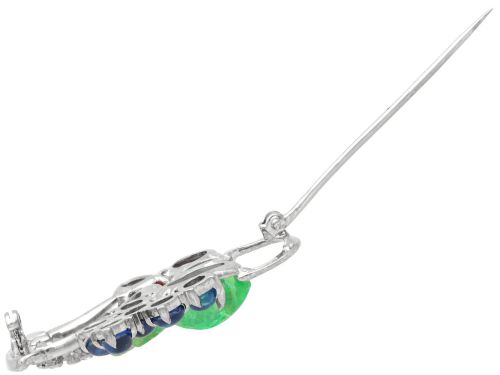 fig 9. An 18ct white gold Tutti Frutti basket brooch featuring carved emeralds, rubies, sapphire cabochons, and small diamonds.