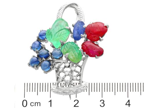 fig 10. An 18ct white gold Tutti Frutti basket brooch featuring carved emeralds, rubies, sapphire cabochons, and small diamonds.