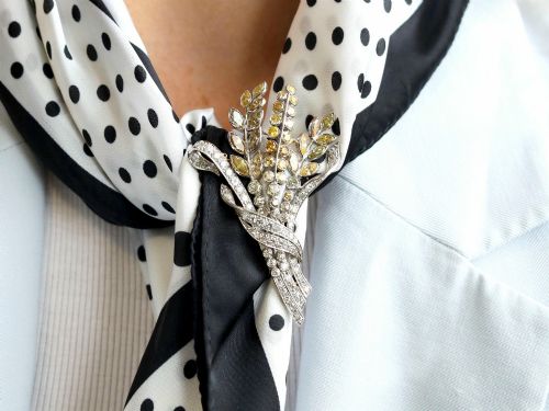 fig 3. An Art Deco diamond brooch designed as a stylized flower spray with yellow and white diamonds mounted in palladium with a safety chain.